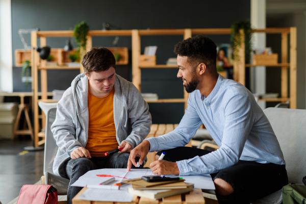 Two young men reviewing a plan together at a desk