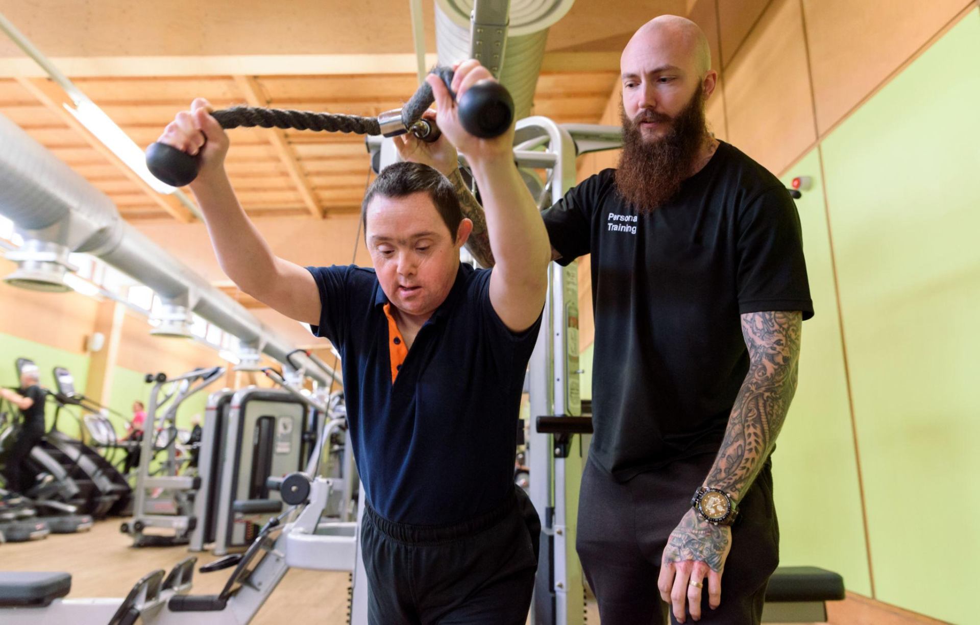 A young man training with a coach in a gym